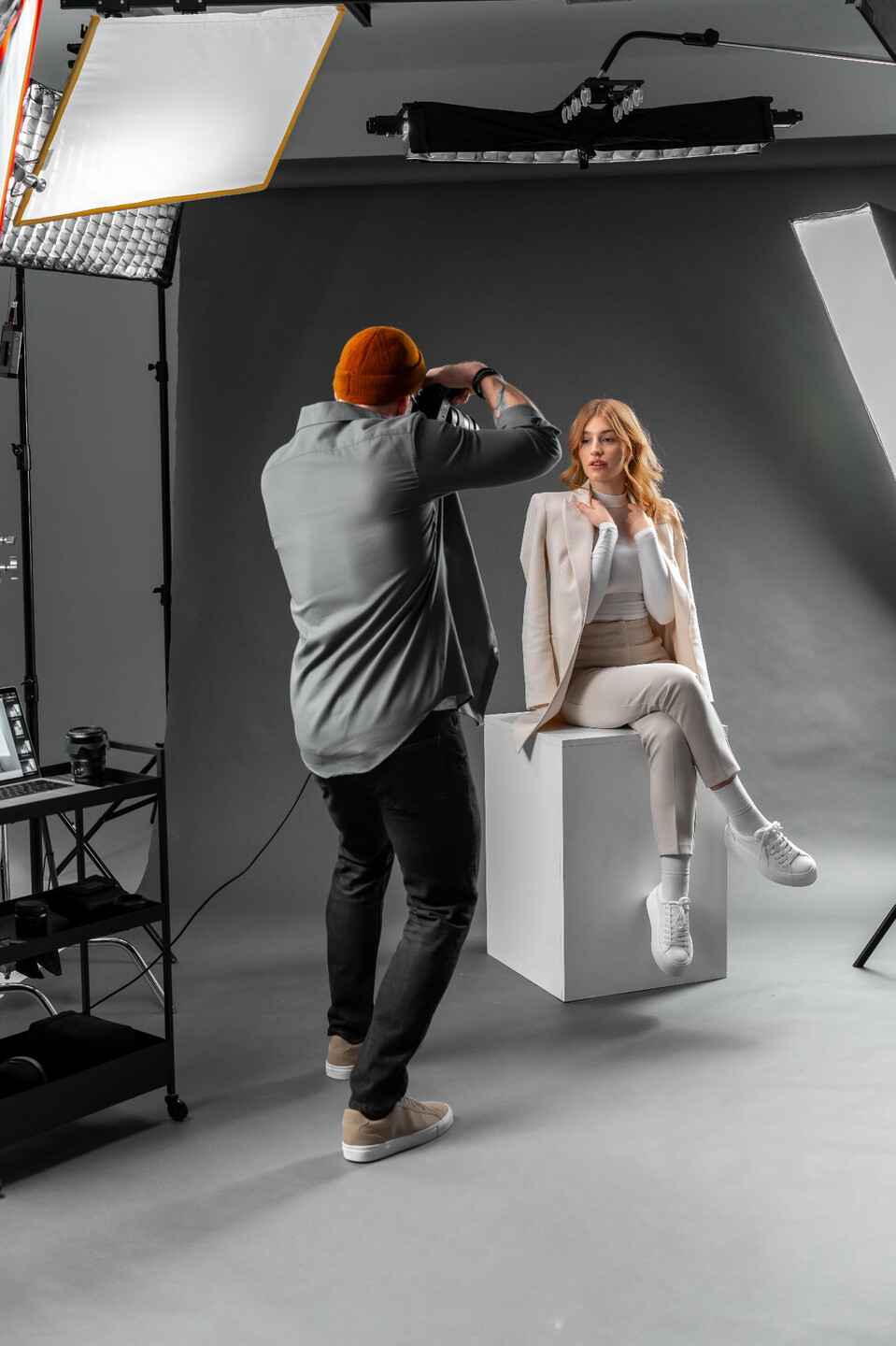 Photographer shooting a model on a lit KASREN production set.